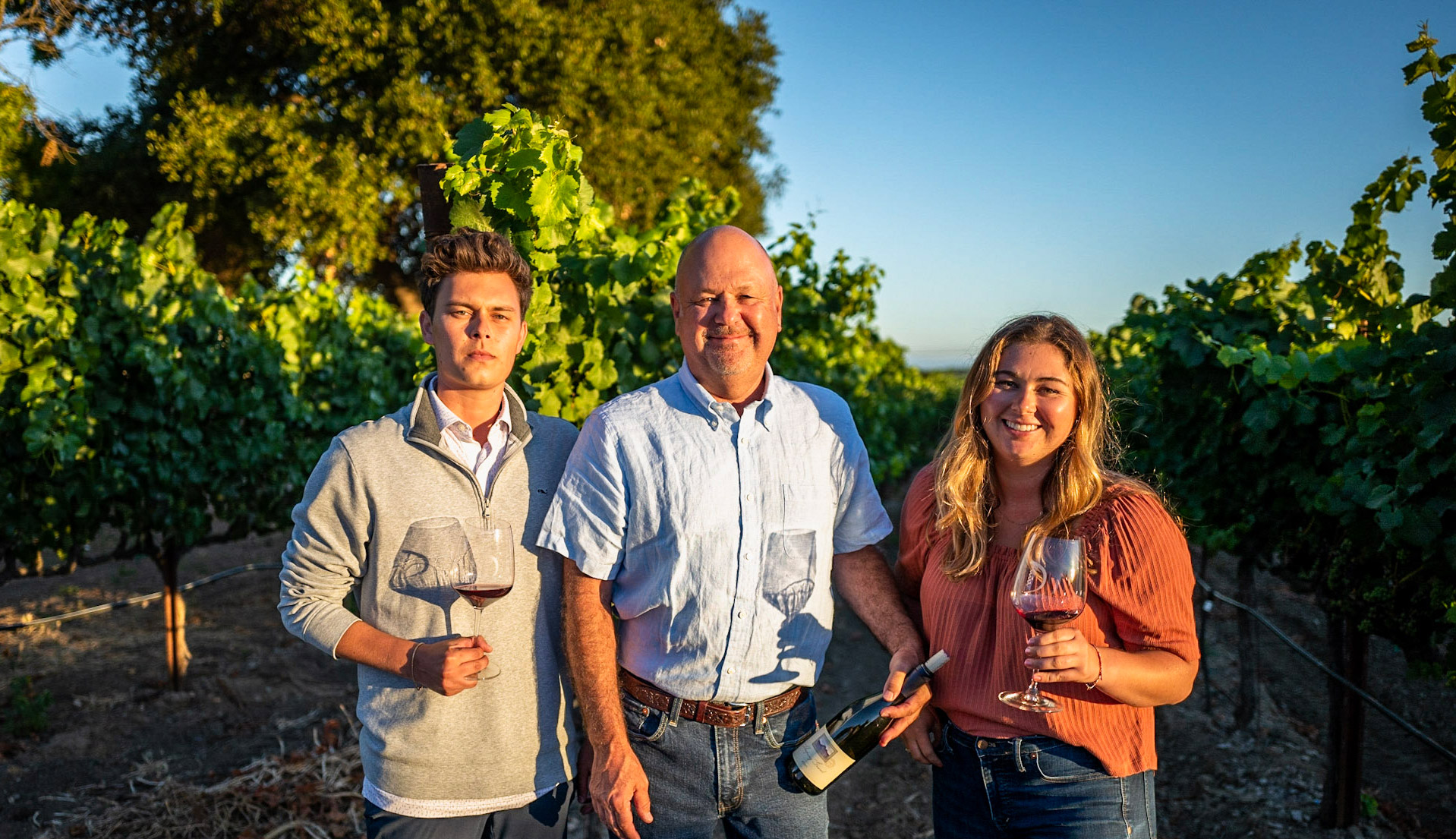 Dearden Family in the vineyard with wine glasses